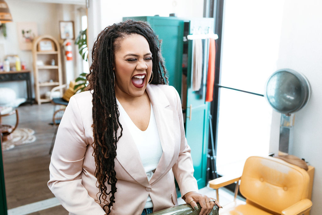 Tiffany Diaz laughing inside her Cheyenne salon — joyful and confident